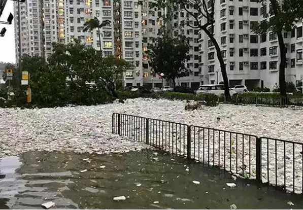 大量垃圾漂浮在还未退去的积水上,包围了居民大楼